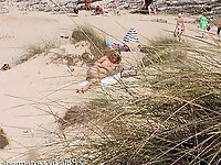 A mature woman feels that she is not being watched on a beach for nudists.